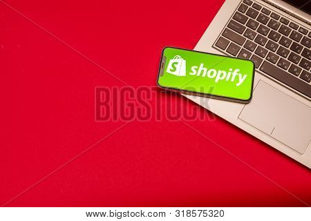 Tula, Russia - August 19, 2019: Shopify Logo On Iphone X On Keyboard Laptop On Red Bsckground