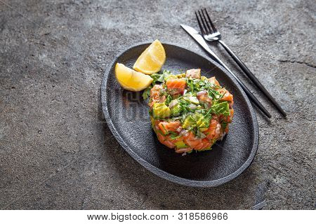 Peruvian Nikkei Food. Salmon Avocado Ceviche On Black Plate, Black Background Top View