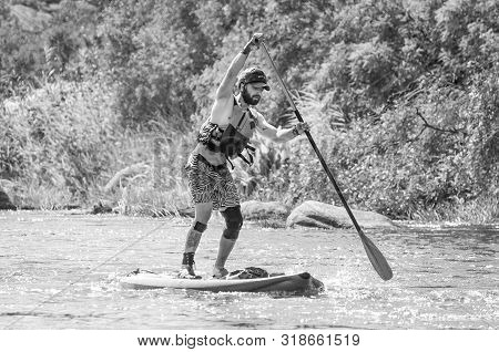 Myhiya, Ukraine - August 17, 2019: Sportsman Paddling Whitewater River On A Inflatable Stand Up Padd