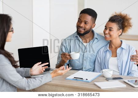 Happy Homebuyers. African American Spouses Having Consultation In Real Estate Agency. Selective Focu