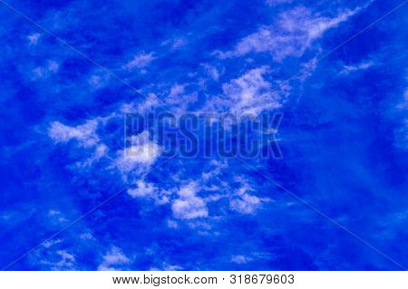 Blue Sky With Feathery White Clouds. Bottom View.