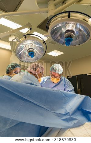 Melbourne, Australia - June 7, 2019: Surgeons Performing A Caesarean Section In An Operating Theatre