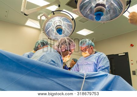 Melbourne, Australia - June 7, 2019: Surgeons Performing A Caesarean Section In An Operating Theatre