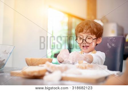 Asian Kid Helping Mom For Cooking. Preparing An Ingredient With Powder And Flour. Reaxing And Happy 