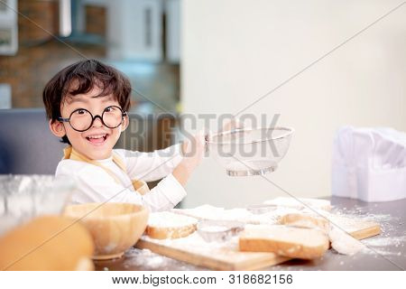 Asian Kid Helping Mom For Cooking. Preparing An Ingredient With Powder And Flour. Reaxing And Happy 