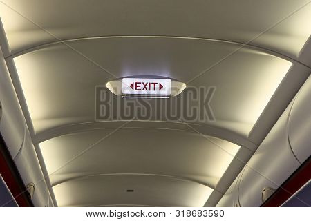 Ilumanated Exit Sign In An Airplane Alley