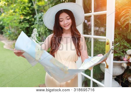 Young And Cute Asian Woman Searching Location In A Map During Holiday
