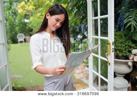 Young And Cute Asian Woman Searching Location In A Map During Holiday