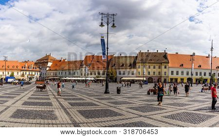 Sibiu, Romania - 2019. Tourist Wondering In The Panoramic The Big Square (piata Mare) Of Sibiu Looki