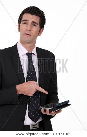 Businessperson ชี้ไปที่เครื่องคิดเลข