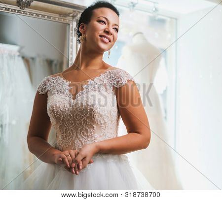 Beautifu bride choosing wedding dress in a wedding salon