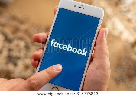 Palo Alto / Usa - August 08 2019: Female Hand With Apple Phone With Logo Of Social Media Facebook On