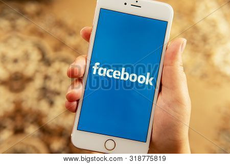 Palo Alto / Usa - August 08 2019: Person Hand With Apple Phone With Logo Of Social Media Facebook On