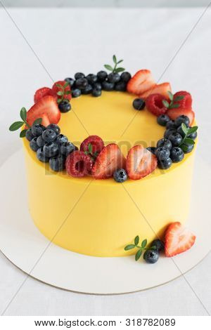 Bright, Festive, Yellow Cake, A Wreath Of Fresh Berries