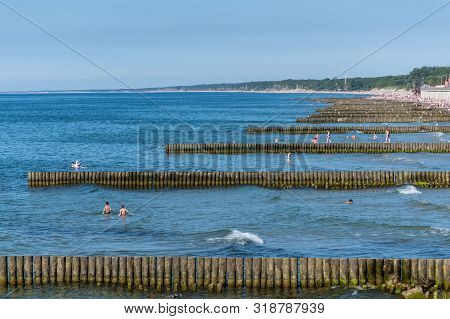 Beach With Wooden Breakwater. Beautiful Seascape. Protection Holidaymakers From Effects Of Both Weat