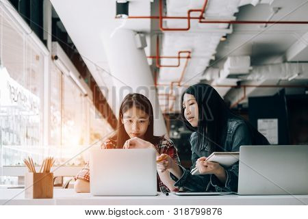 Young Studebt Sitting In Library College Studying And Sharing Knowledge With Laptop Together, Educat