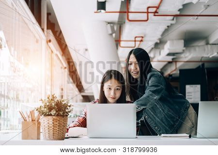 Young Studebt Sitting In Library College Studying And Sharing Knowledge With Laptop Together, Educat