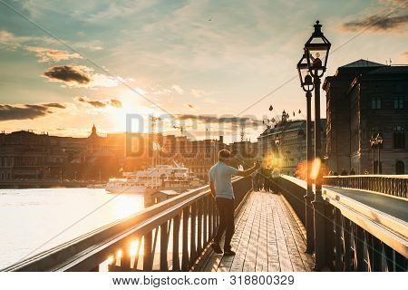 Stockholm, Sweden - June 27, 2019: Man Tourist Traveler Taking Pictures Photos Near Famous Skeppshol