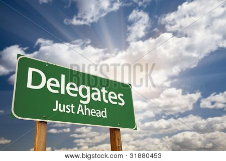 Delegati Green Road Sign con drammatiche nuvole, sole raggi e Sky.