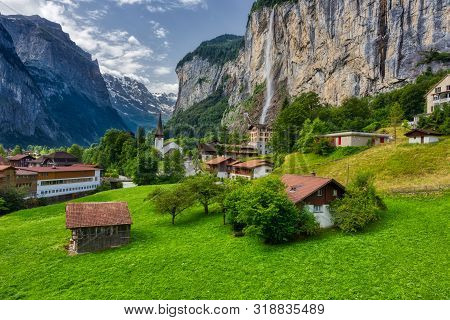 View Of Lauterbrunnen Town In Swiss Alps Valley With Gorgeous Staubbach Waterfalls In The Background