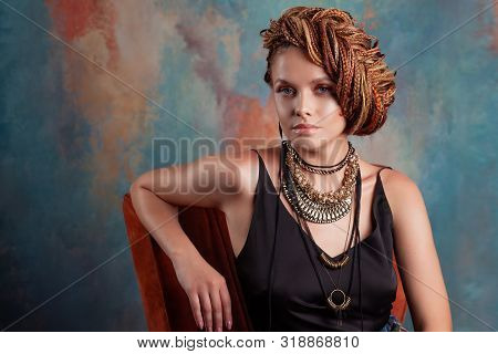 Southern Flavor. Stylish Beautiful Young Woman With Afro Braids Tucked Into A High Hair, Sitting In 