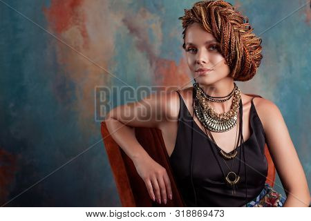 Southern Flavor. Stylish Beautiful Young Woman With Afro Braids Tucked Into A High Hair, Sitting In 