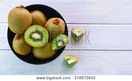Kiwi Slice In Bowl / Fresh Kiwi Fruit On The Table Wooden Background , Top View