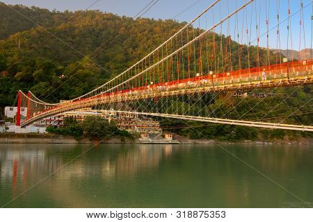 Ram Jhula Bridge Of Rishikesh Over Holy River Ganges, A Suspension Bridge Famous For Association Wit
