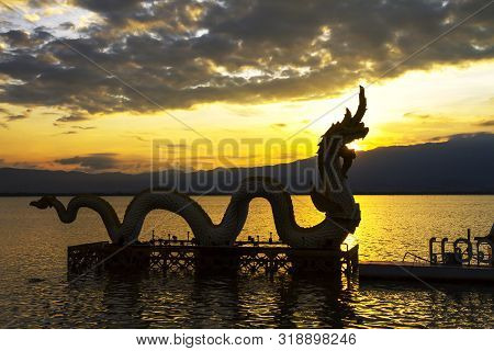 Sunset Beautiful And Silhouette Of Statue Dragon On Kwan Phayao, Phayao Province In Countryside,thai