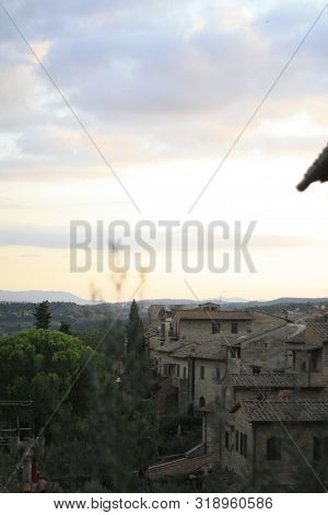 Ancient Tuscan Walled City Houses With Towers And Stone Walls And Paved Cobbled Streets In Italy