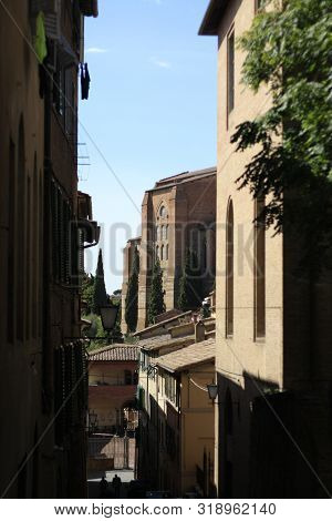 Ancient Tuscan Walled City Houses With Towers And Stone Walls And Paved Cobbled Streets In Italy