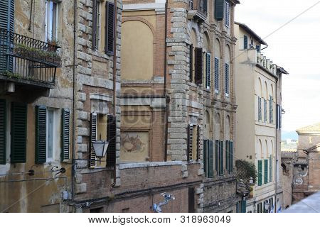 Ancient Tuscan Walled City Houses With Towers And Stone Walls And Paved Cobbled Streets In Italy