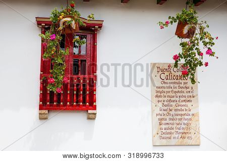 Mongui, Colombia - August, 2019: Sign Telling The Story Of The Royal Bridge Of Calicanto At The Smal