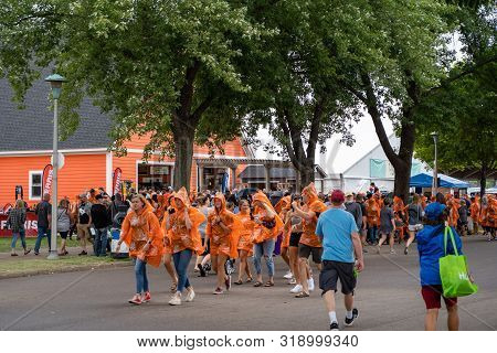 Falcon Heights, Mn - August 25, 2019: Fairgoers Grab Home Depot Plastic Rain Ponchos At The Booth As