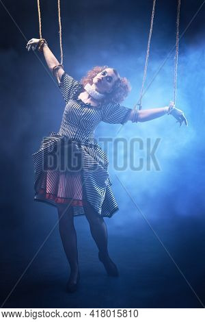 Puppet theater and circus. The actress plays a doll on strings at a performance in a puppet theater. Full length portrait in vintage style.