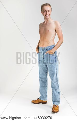 Full Length Portarit Of Smiling Caucasian Handsome Man Posing With Naked Torso On White Background.