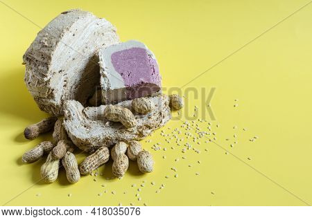 Peanut And Sesame Halva With Decoration In The Form Of Peanuts And Sesame Seeds On A Yellow Backgrou