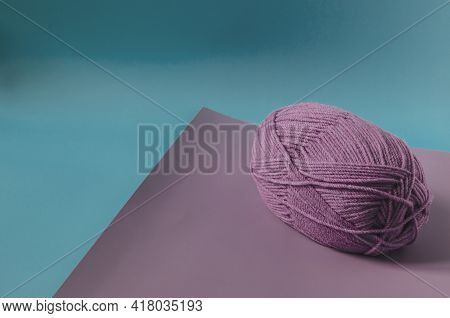 A Ball Of Lilac Yarn On A Colored Background Close-up. Knitting In Self-isolation