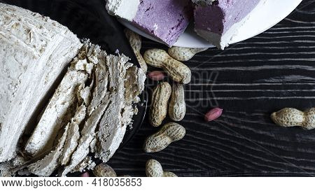 Peanut And Sesame Halva With Decoration In The Form Of Peanuts And Sesame Seeds On A Dark Wooden Bac