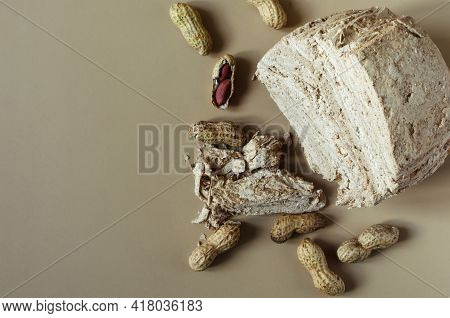Peanut Halva And Peanut Nuts On A Light Brown Background Top View Of Kopi Space. Halva Oriental Swee
