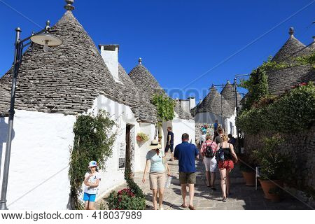 Alberobello, Italy - May 29, 2017: Tourists Visit Alberobello, Italy. Alberobello And Its Trulli Hou