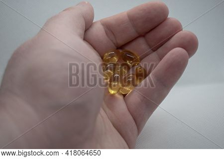 Man's Hand Holding Fish Oil Capsules.fish Oils Capsules As A Dietary Supplement Containg Omega-3 For