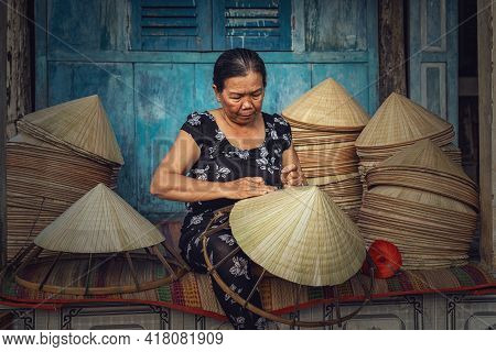Vietnamese Old Woman Craftsman Making The Traditional Vietnam Hat In The Old Traditional House In Ap
