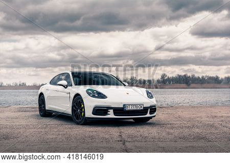 Kherson, Ukraine - March 2021. Hybrid Porsche Panamera 4 In A White Color On The Background Of The R