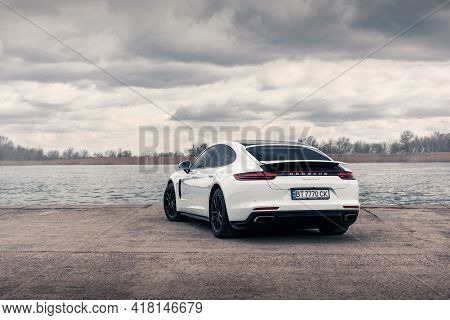 Kherson, Ukraine - March 2021. Hybrid Porsche Panamera 4 In A White Color On The Background Of The R