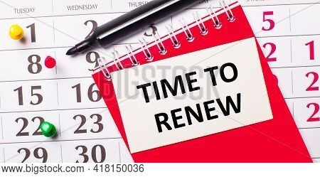 On The Calendar Is A White Card With The Text Time To Renew. Nearby Is A Red Notepad And A Marker. V