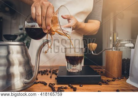Barista Holding Coffee Drip Jug Pour Coffee To Glass Cup. Making Filter Coffee. Drip Coffee.