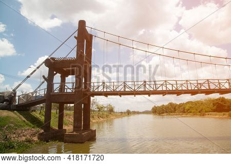 Wooden Suspension Bridge That Crosses A Reservoir In A Public Park In Thailand.