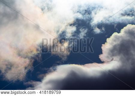 White Clouds With Iridescence Against The Blue Sky