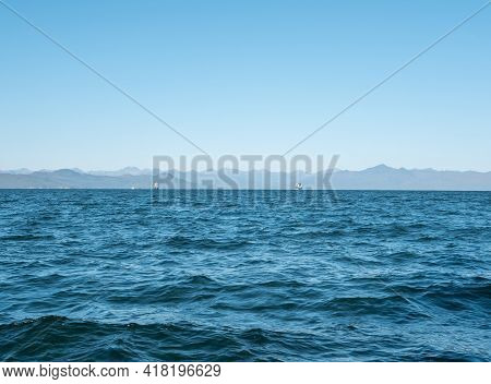 Exit On A Yacht To The Avacha Bay Of The Pacific Ocean. Large Ships On The Horizon Sail Towards The 